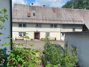 a white house with a metal roof and a yard at NEU! Ferienwohnung Bruno in Gersfeld