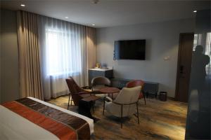 a hotel room with a bed and a table and chairs at Happiness Hotel Ulaanbaatar in Ulaanbaatar +27 photos
