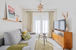 a living room with a couch and a flat screen tv at Appartment SPATZENNEST in Bietigheim-Bissingen