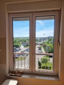 a window with a view of a parking lot at Vels Suite - Cozy Oasis & Free Parking in Voždivac +12 photos