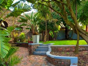 a garden with stairs and trees and a building at Hidden Gem Self-catering RUWARI BRACKENFELL CAPE TOWN in Cape Town