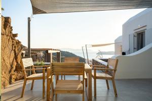 a wooden table and chairs on a balcony at Sea and Sun ll in Ios Chora
