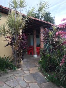 a patio of a house with palm trees and plants at Suítes Dona Ilda in Pirenópolis