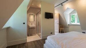 a bedroom with a bed and a bathroom with a sink at Bakkumer Strand in Castricum