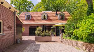 a brick house with an umbrella in a courtyard at Bakkumer Strand in Castricum