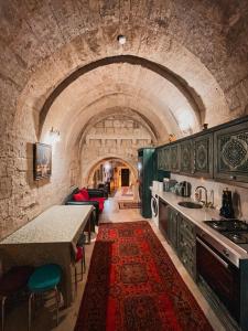 a kitchen with a counter and a table in a room at Masar Cave Konak in Ortahisar