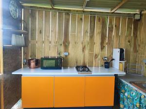 a kitchen with an orange and white counter top at Le Nid des Prairies in La Chapelle-Engerbold