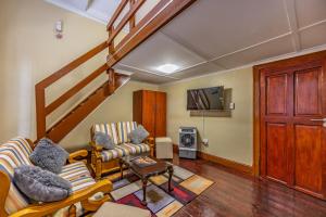 a living room with two couches and a staircase at The 196 City Lodge in Pretoria