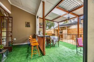 a living room with a table and chairs and a balcony at The 196 City Lodge in Pretoria