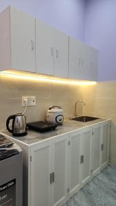 a kitchen with white cabinets and a sink at Minihouse Út Thiểu in Rạch Giá