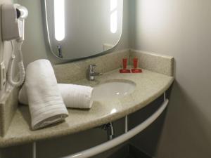 a bathroom with a sink and a mirror at ibis Itatiba in Itatiba +78 photos