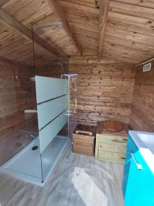 a room with a wooden wall and a glass refrigerator at Le Nid des Prairies in La Chapelle-Engerbold
