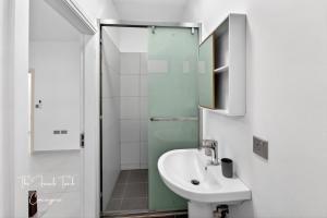 a white bathroom with a sink and a shower at The Jacuzzi Escape in Flic-en-Flac +23 photos
