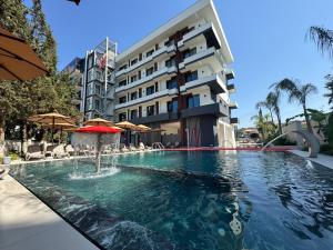 a swimming pool with a fountain in front of a building at Hotel Kraja in Golem