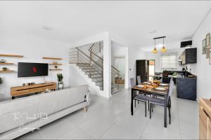a living room with a couch and a dining room at The Jacuzzi Escape in Flic-en-Flac