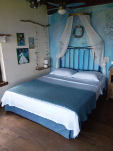 a bedroom with a bed with blue walls at Feggaropetra Inn Magic Mountain House in Palaios Panteleimonas