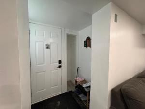 a room with a white door and a bedroom at Silverado Suite Modern Quiet 2BR Queen's Downtown in Kingston