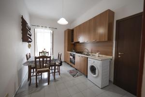a kitchen with a washing machine and a table with chairs at Casa bea in Taranto