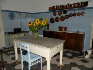 una cocina con una mesa con un jarrón de girasoles. en Villa Adele, en Varese