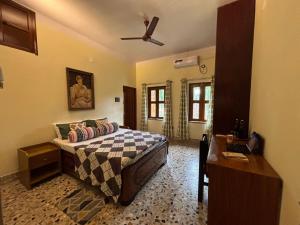 a bedroom with a bed and a ceiling fan at Prangan - The Villa in Chākdaha