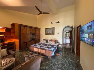 a living room with a bed and a flat screen tv at Prangan - The Villa in Chākdaha