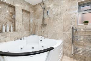 a bathroom with a white tub and a shower at Riverside Villas in Manchester +79 photos