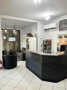 a lobby with a bar and a living room at Hotel Ceolatto in Várzea Grande