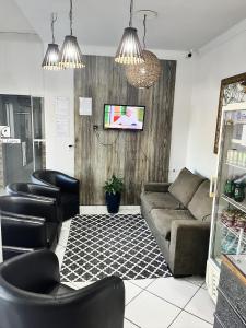 a living room with a couch and black chairs at Hotel Ceolatto in Várzea Grande