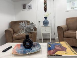 a vase with flowers on a table in a living room at Silverado Suite Modern Quiet 2BR Queen's Downtown in Kingston