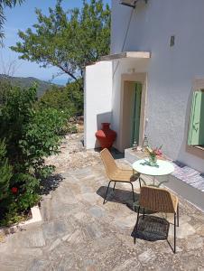 a patio with a table and chairs and a toilet at Villa Pefkias in Skopelos Town