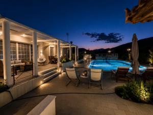 a backyard patio with a swimming pool at night at Elia Apartment Garden Oasis With Pool Astros in Paralio Astros