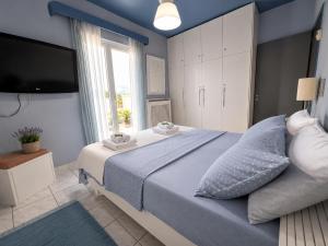 a bedroom with a large bed with a tv on the wall at Elia Apartment Garden Oasis With Pool Astros in Paralio Astros +31 photos