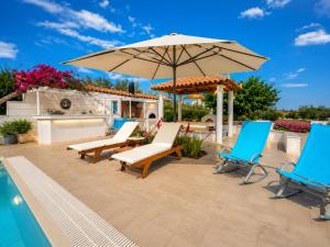 a patio with chairs and an umbrella next to a swimming pool at Elia Apartment Garden Oasis With Pool Astros in Paralio Astros