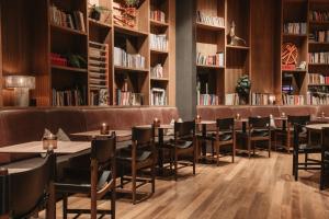 a restaurant with tables and chairs in a library at Home Hotel Folketeateret in Oslo