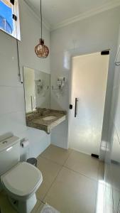 a bathroom with a toilet and a sink and a mirror at Hotel e Restaurante Os Sertões in Canudos +21 photos