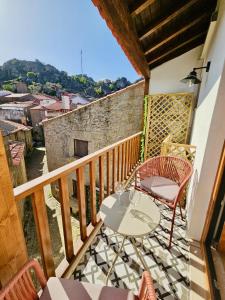 a balcony with a table and chairs and a view at Casa Laura João in Monsanto +6 photos