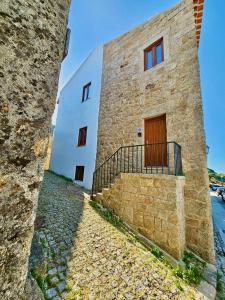 a large stone building with a door and a fence at Casa Laura João in Monsanto