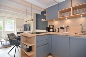 a kitchen with blue cabinets and a counter top at Alma & Eva, Whg 5 in Westerland