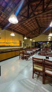 a dining hall with wooden benches and lights at Hotel e Restaurante Os Sertões in Canudos