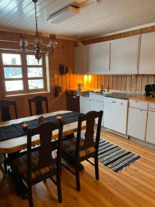 a kitchen with a wooden table and a table and chairs at Toppastranda 20 in Sør-Fron