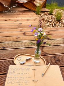 a table with a vase of flowers and a note at Srnčí vrch in Batňovice