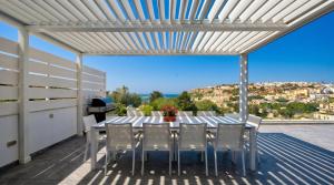 a table and chairs on a patio with a view at Villa Ghea - Indoor Jacuzzi Pool, Sauna and Games Room in Mellieħa