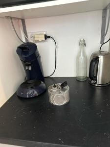 a black counter top with a coffee maker and a blender at Studio l'Enchantement in La Ciotat