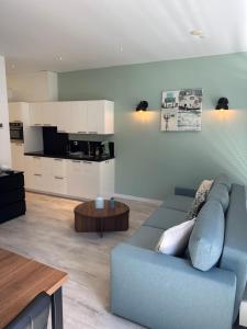 a living room with a blue couch and a table at De Wulk 26 in Zandvoort +3 photos