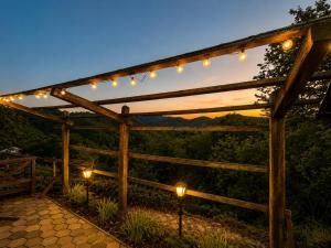 a wooden pergola with lights on it at night at Zidanica Jakec Wine House & Scenic Views in Podlehnik