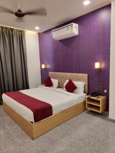 a bedroom with a large bed and a purple wall at Hotel The Crown Prince in Jaipur