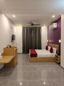 a hotel room with a bed and a desk at Hotel The Crown Prince in Jaipur