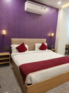 a bedroom with a large bed with red pillows at Hotel The Crown Prince in Jaipur
