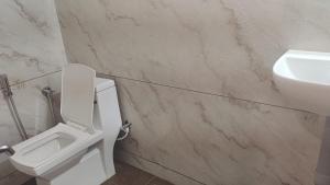 a bathroom with a white toilet and a sink at His Grace Holiday Home - Nr to Malpe Beach in Udupi