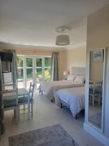 a bedroom with two beds and a table and chairs at Spring Grove Guesthouse in Donegal